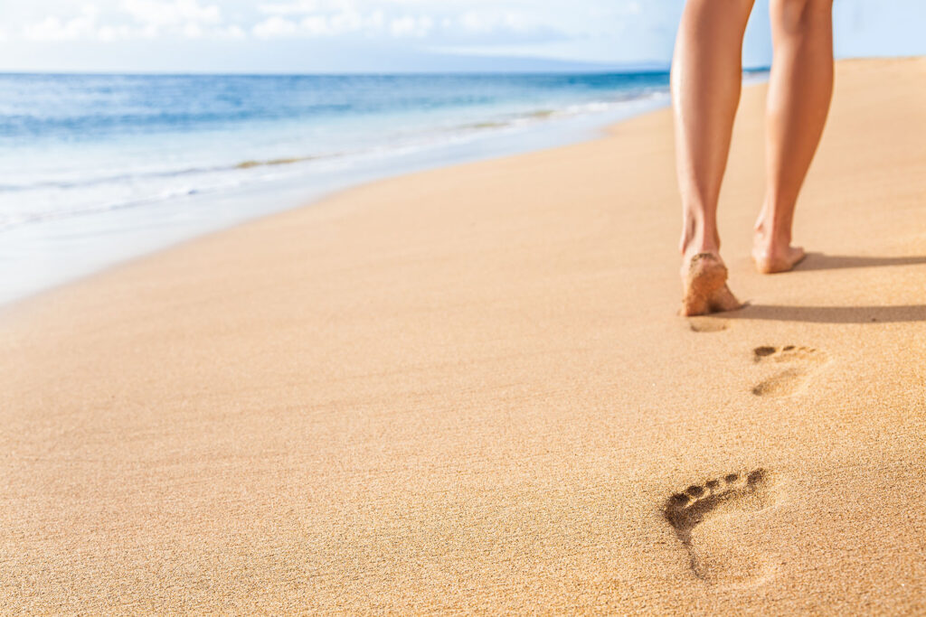 Woman relaxing walking on sand beach.
