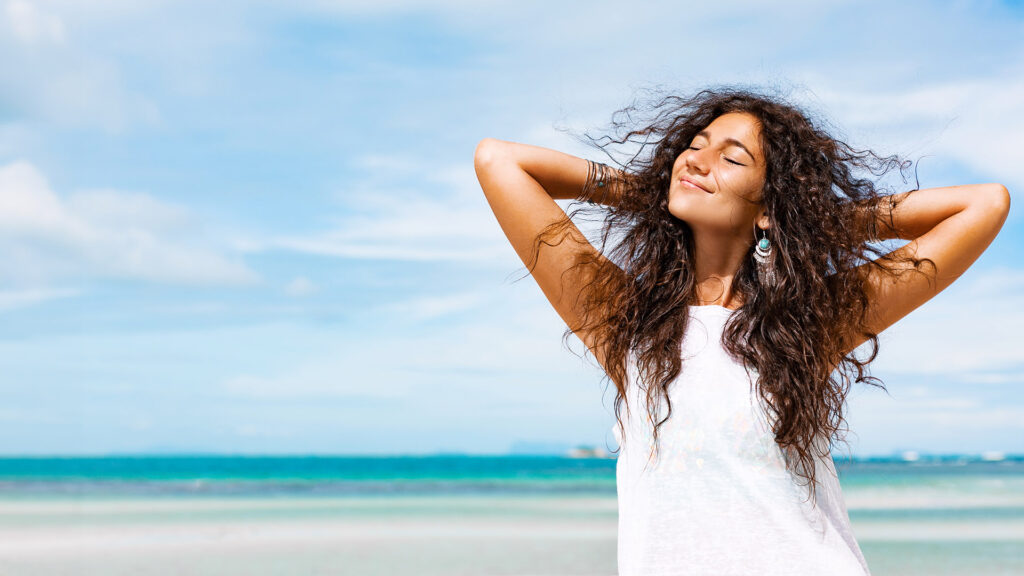 young cheerful woman having fun on the beach