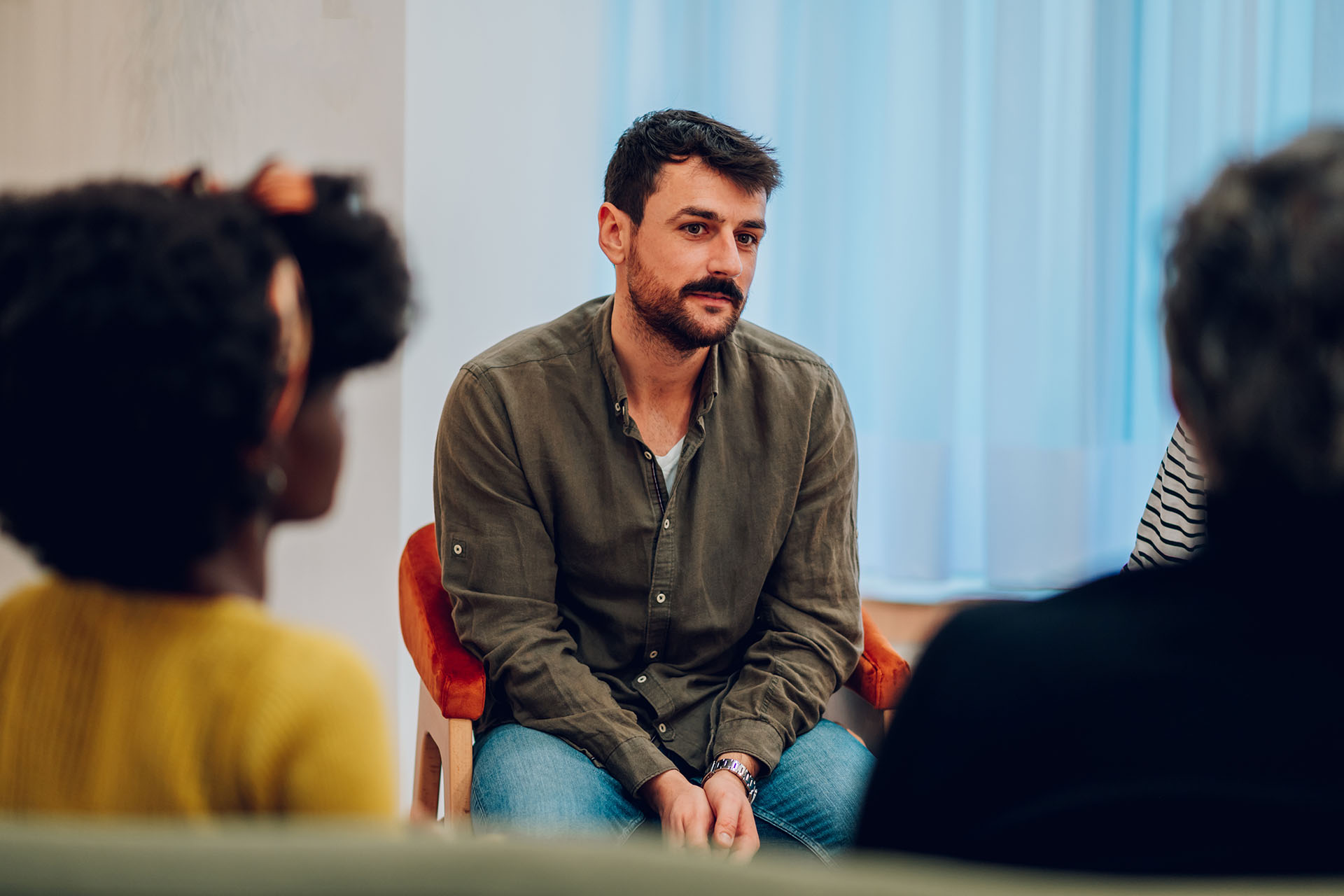 Young man talking about his mental health on a group therapy session